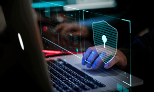 A person typing on laptop with virtual security issue sign